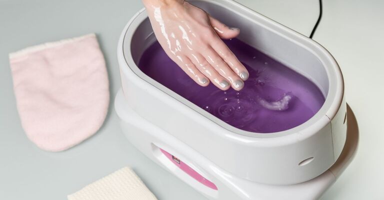 Una donna inserisce la mano all'interno della paraffina