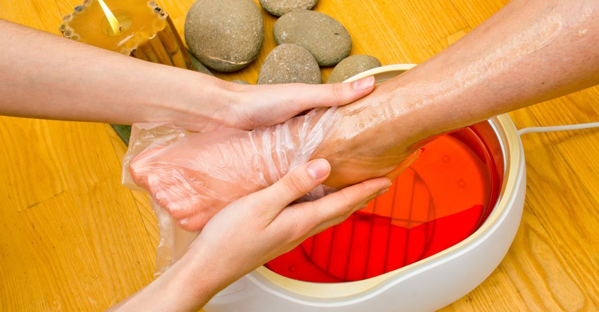 Una donna inserisce il piede all'interno della paraffina