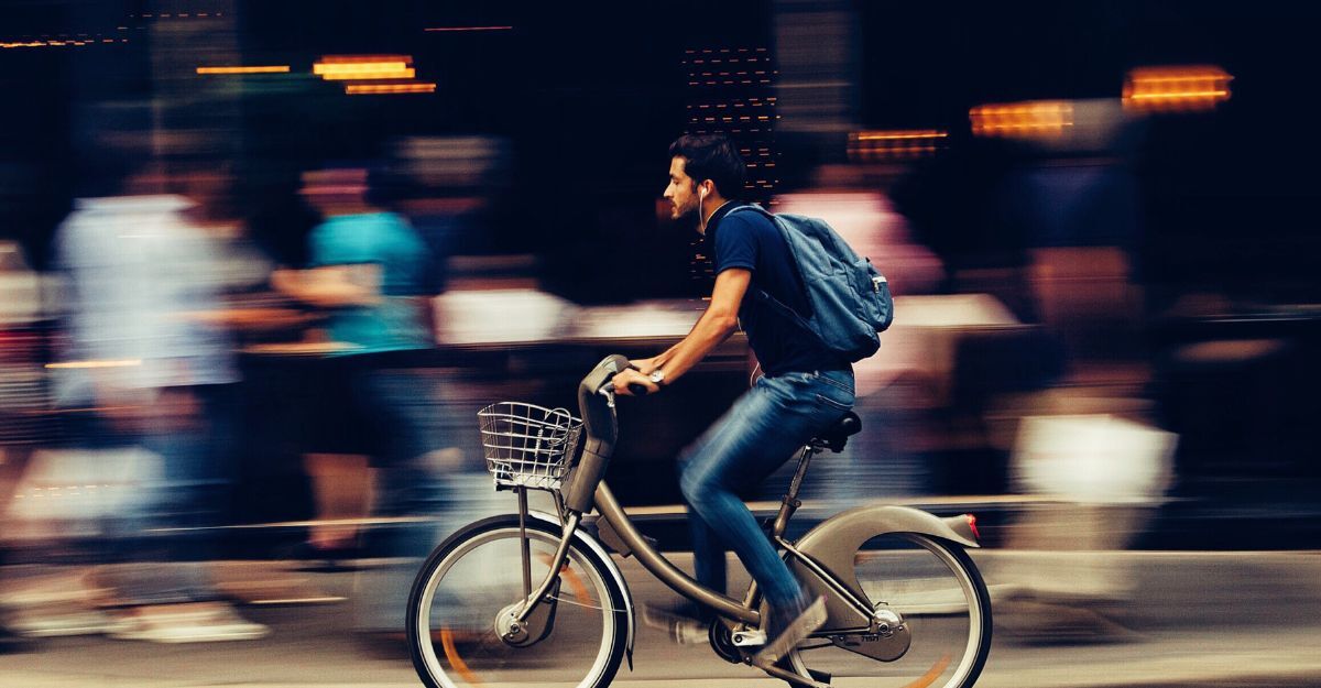 Un ragazzo sfreccia in bicicletta tra la folla