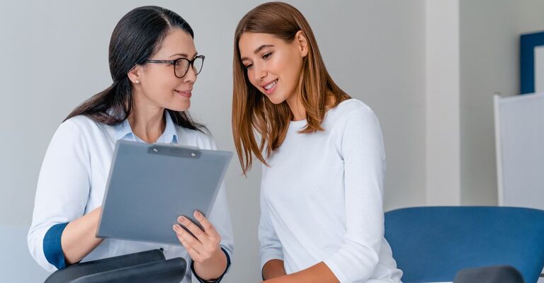 Paziente con ginecologa e cartellina dei risultati delle visite