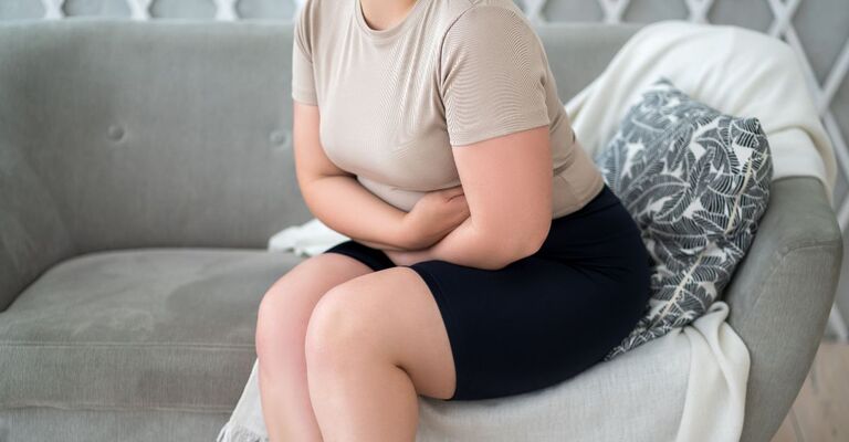 ragazza si tiene la pancia per un dolore