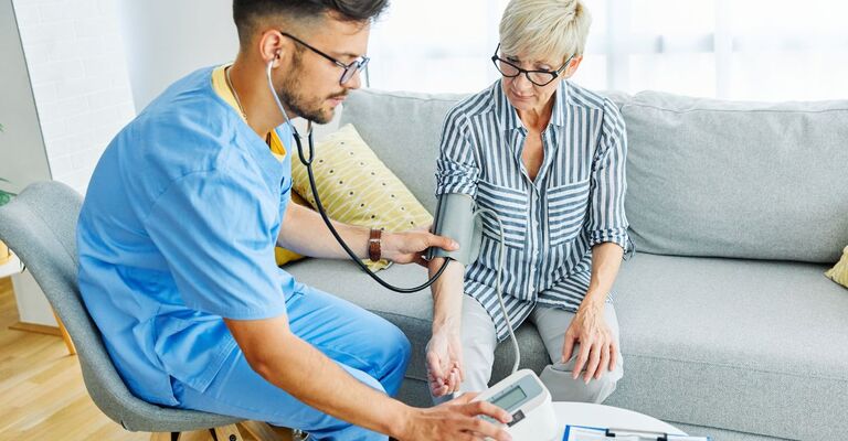 infermiere misura la pressione a paziente