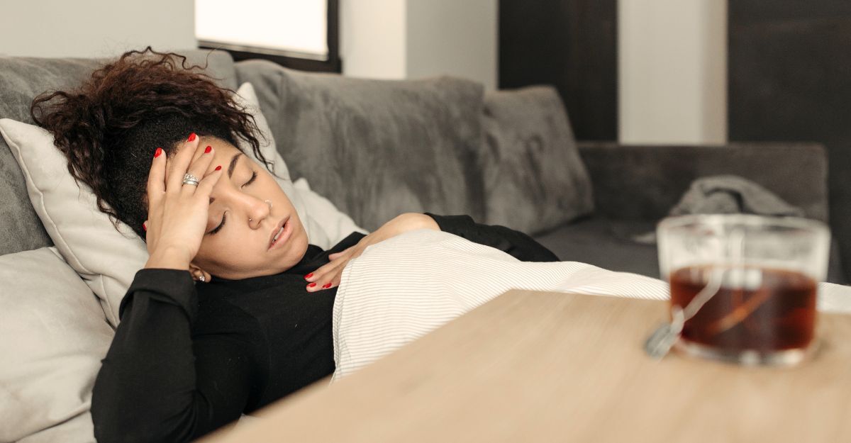 Donna sdraiata sul divano con i sintomi della febbre