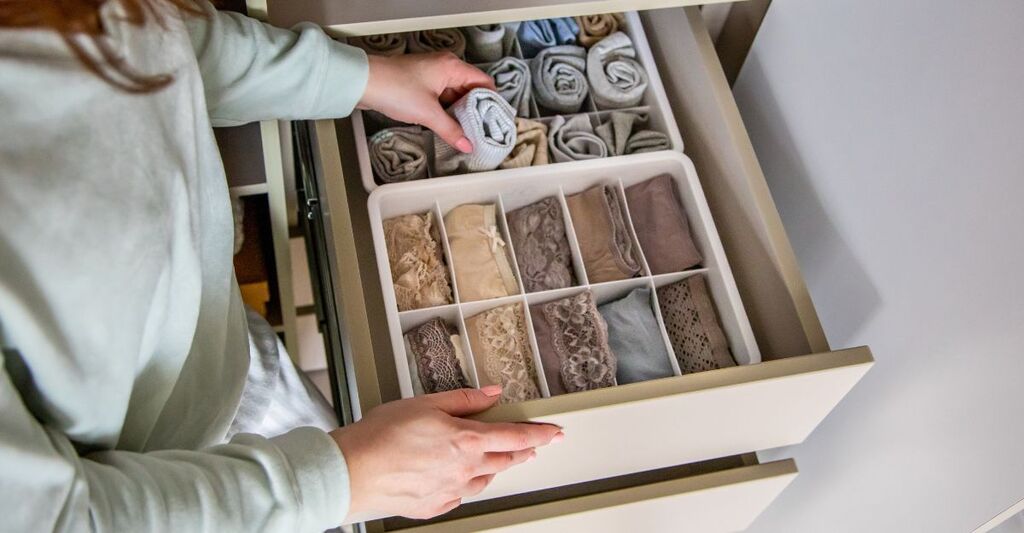Ragazza che riordina un cassetto con biancheria all'interno di un organizer apposito