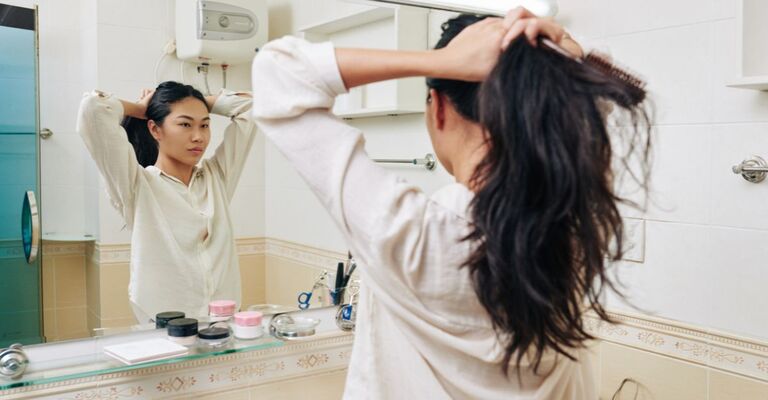 Ragazza davanti allo specchio che procedere a sistemare la coda