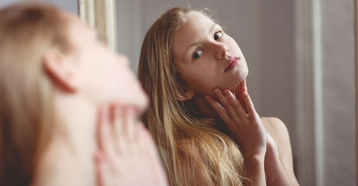 Ragazza giovane osserva il suo viso allo specchio