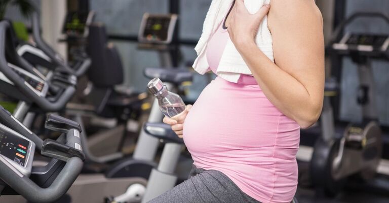 Primo piano sulla pancia di una donna incinta sulla cylcette