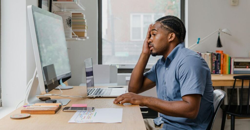 Uomo annoiata al lavoro davanti al PC