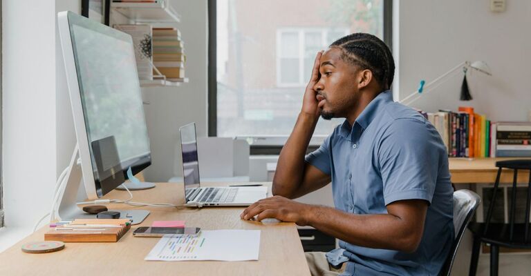 Uomo annoiata al lavoro davanti al PC