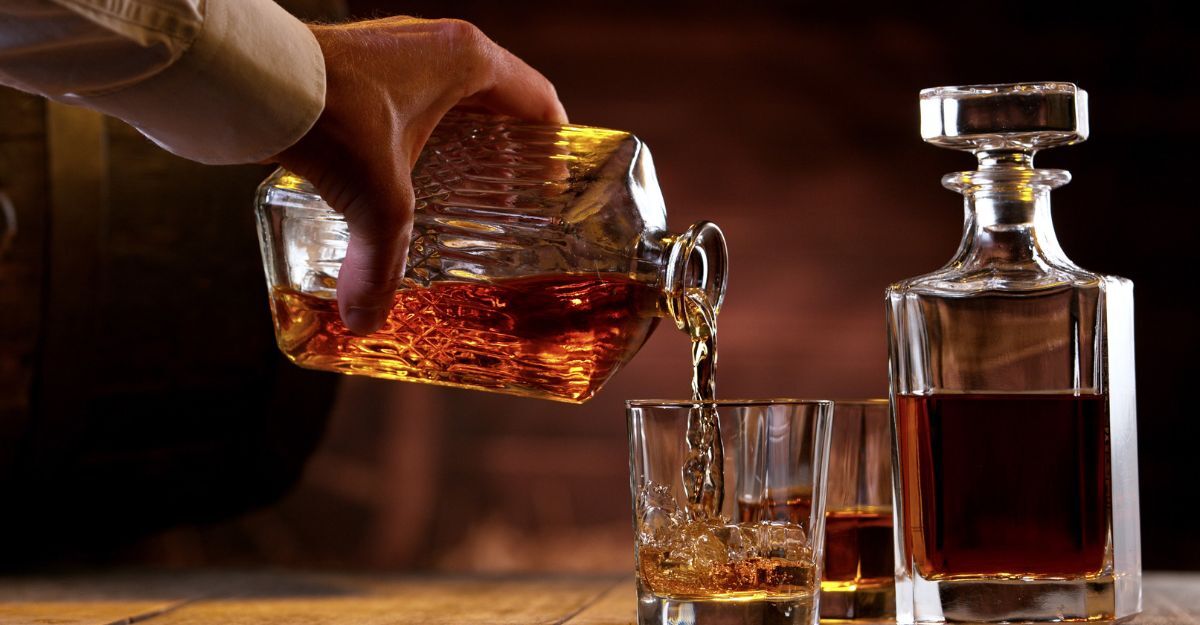 Un uomo che si versa dell'alcol