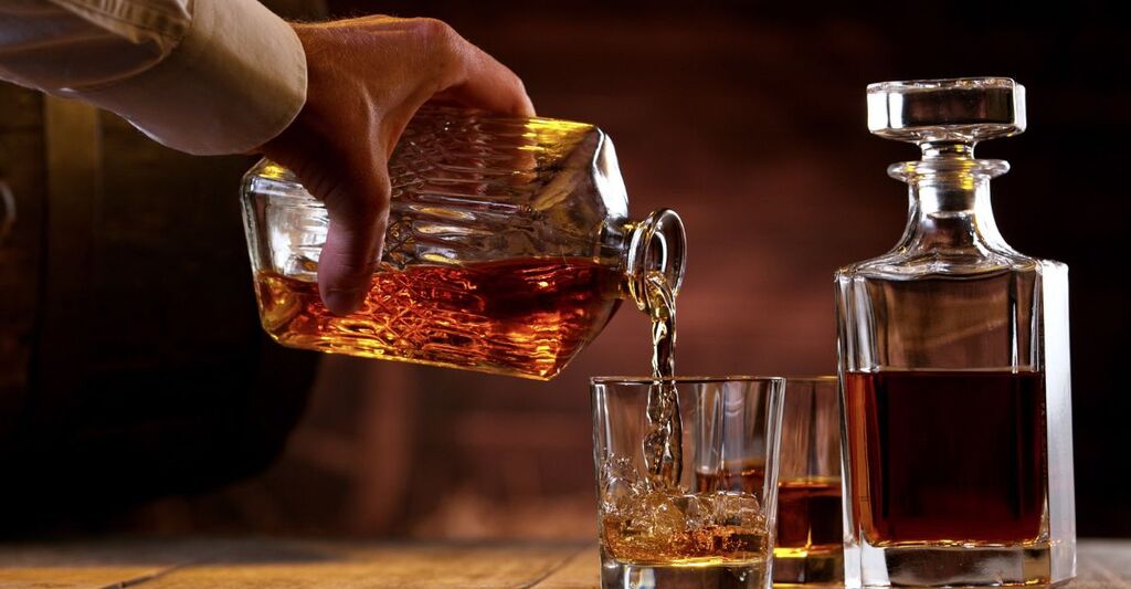 Un uomo che si versa dell'alcol