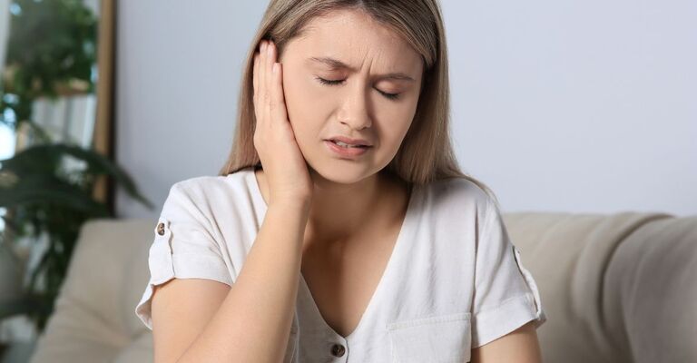 Un ragazza si tiene l'orecchio dolente