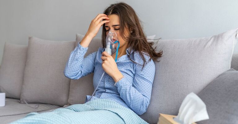 Donna sul divano che fa l'aerosol