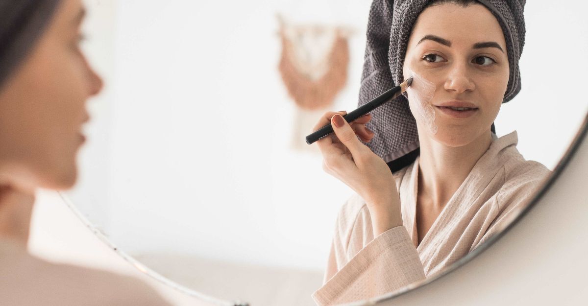 Una donna si fa una maschera viso allo specchio