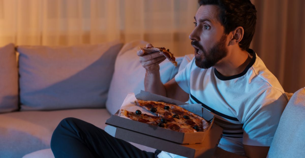 Un ragazzo mangia una pizza di notte