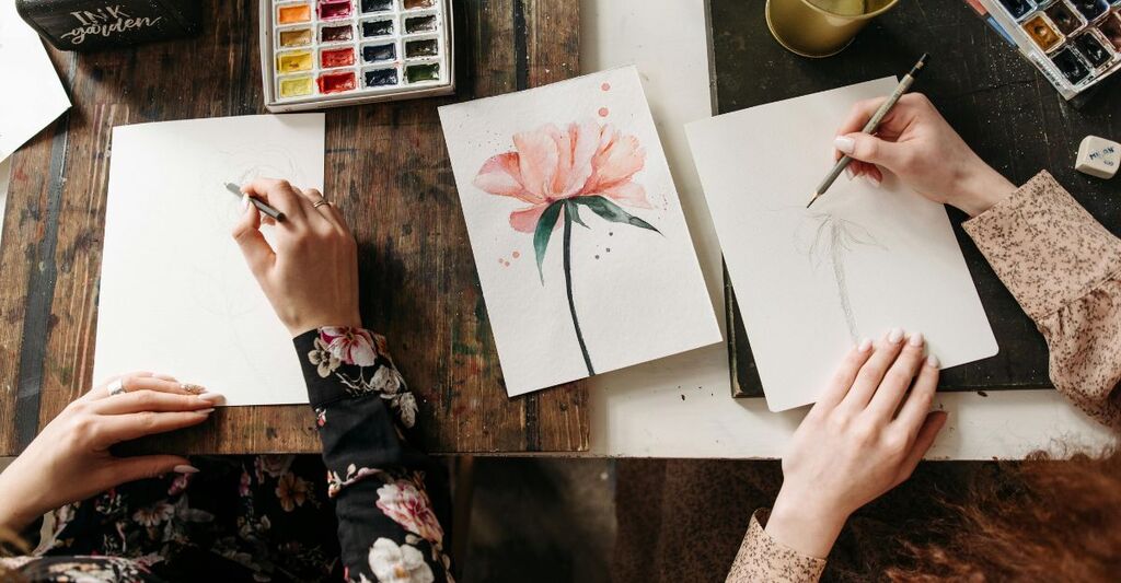 Due donne che dipingono con close-up sulle tele e i colori