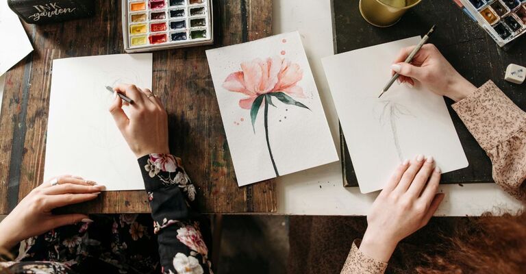 Due donne che dipingono con close-up sulle tele e i colori