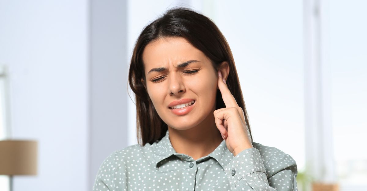 Donna che appoggia due dita all'orecchio perché dolorante