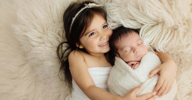 significato edoardo sorellina tiene abbracciato suo fratellino appena nato