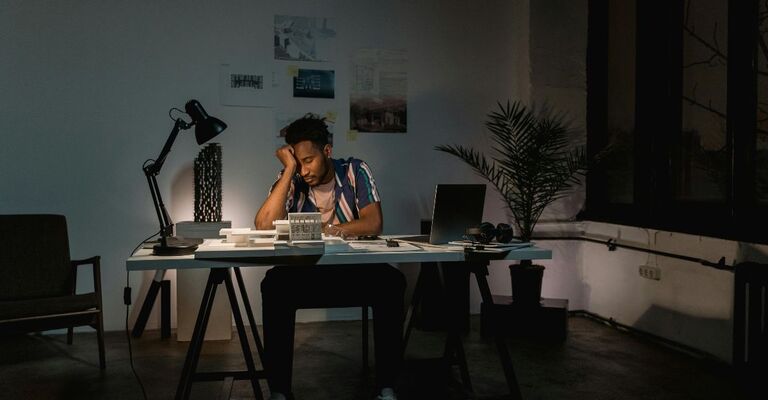 Ragazzo in ufficio con la luce accesa sembra provato