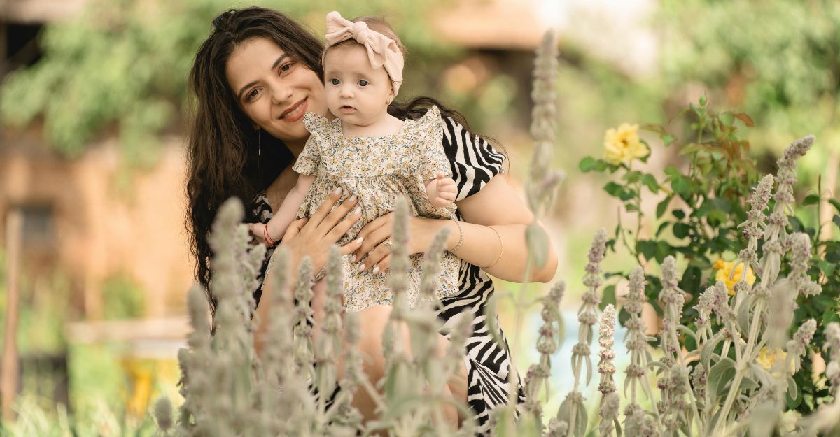 Mamma con figlia in braccio in mezzo a un giardino