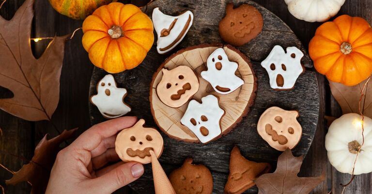 Mano che decora biscotti di Halloween