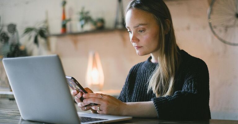 Ragazza che guarda pensierosa il telefono