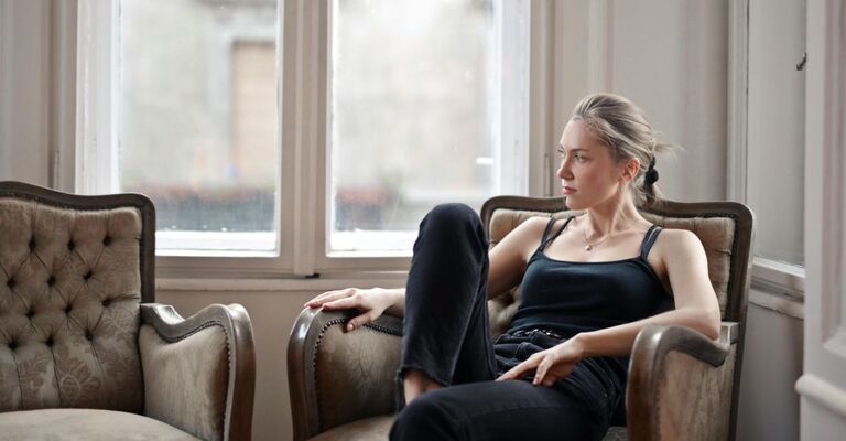 Donna seduta sulla poltrona riflette sul da farsi
