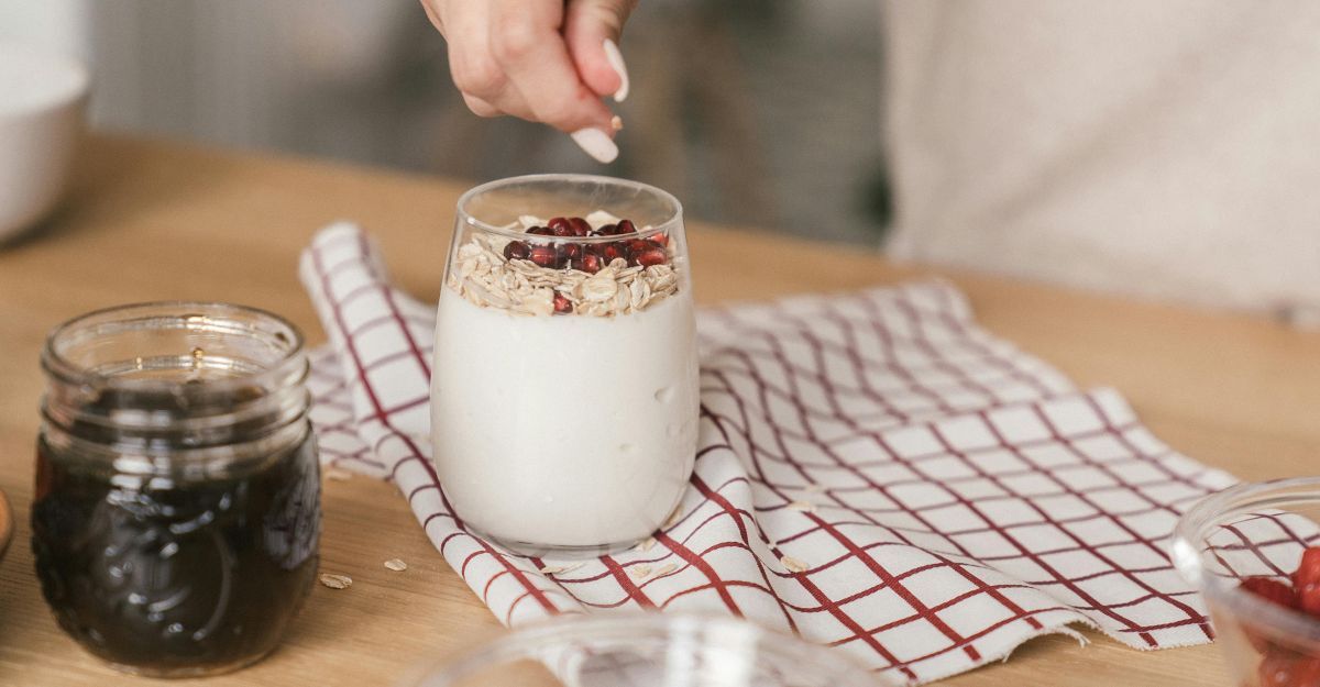 Ragazza prepara yogurt in barattolo con cereali