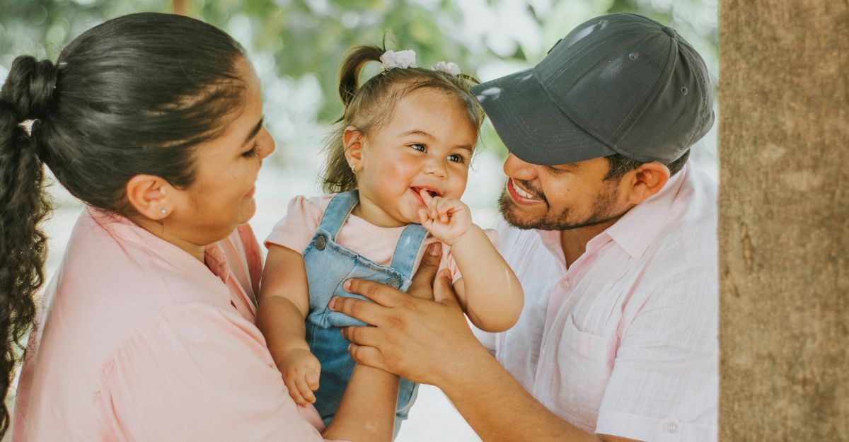 Bambina in braccio a mamma e papà