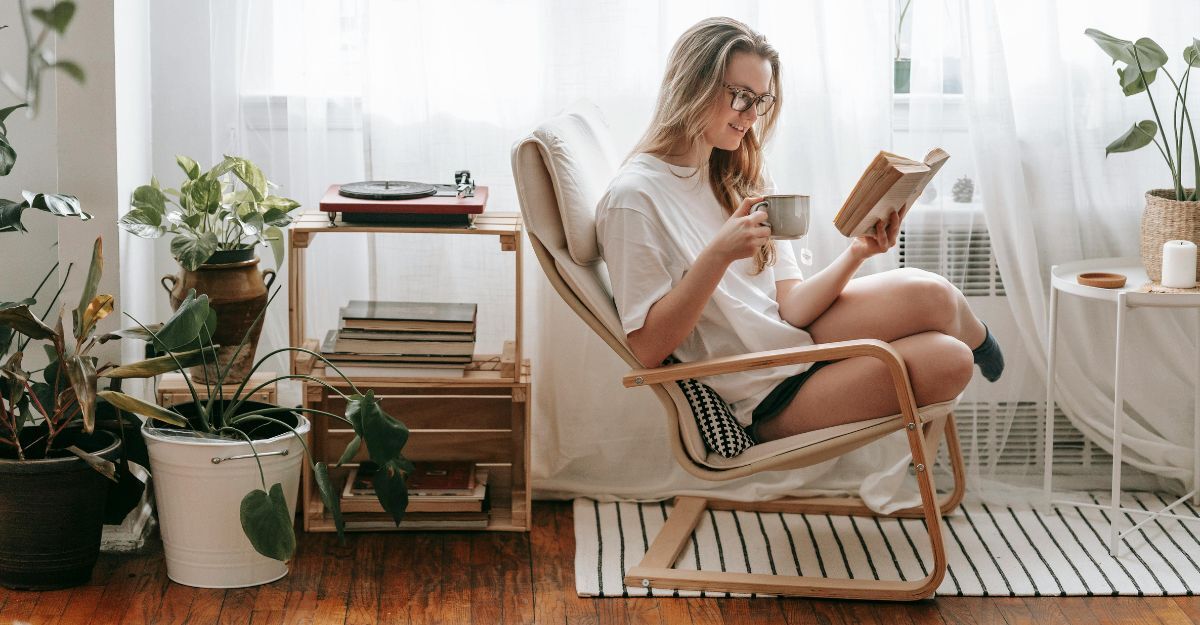 Ragazza che legge un libro in poltrona