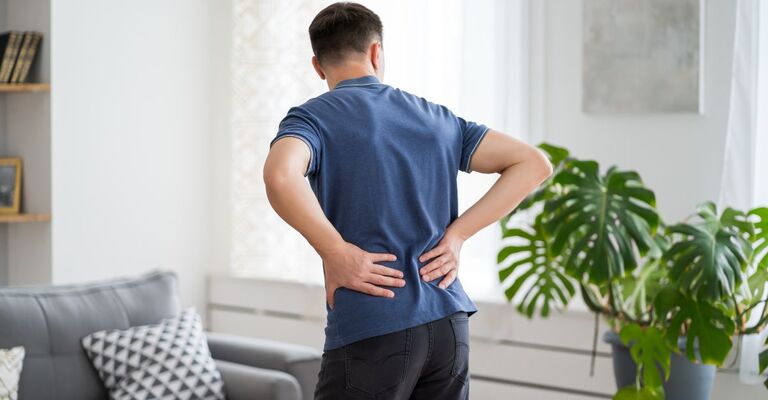 Un ragazzo si tocca la schiena dolorante
