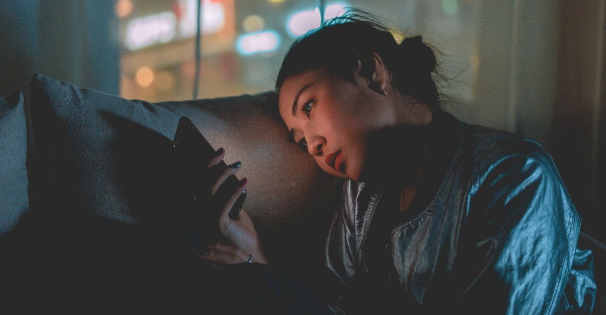 Ragazza che guarda il cellulare al buio