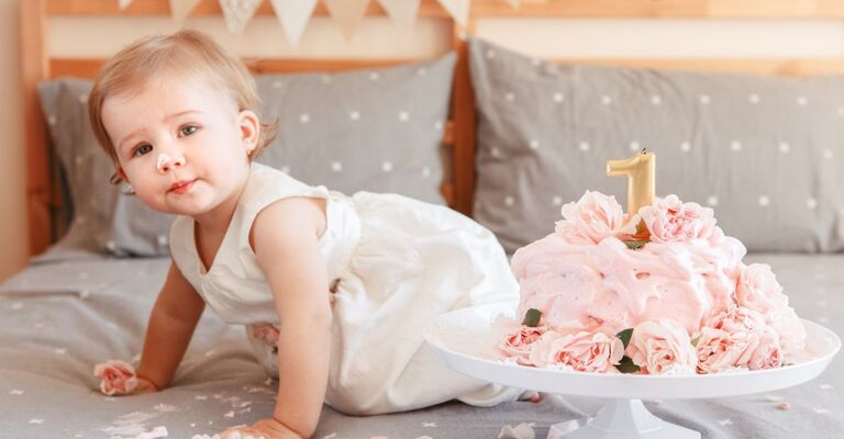 Una bambina davanti a una torta di compleanno
