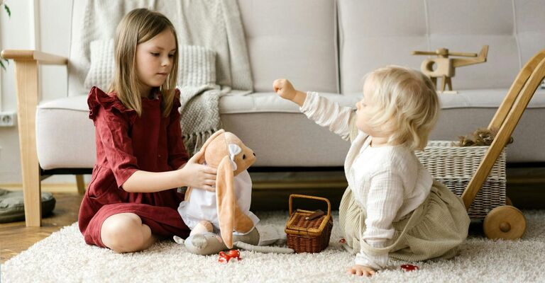 Bambina e neonata che giocano insieme