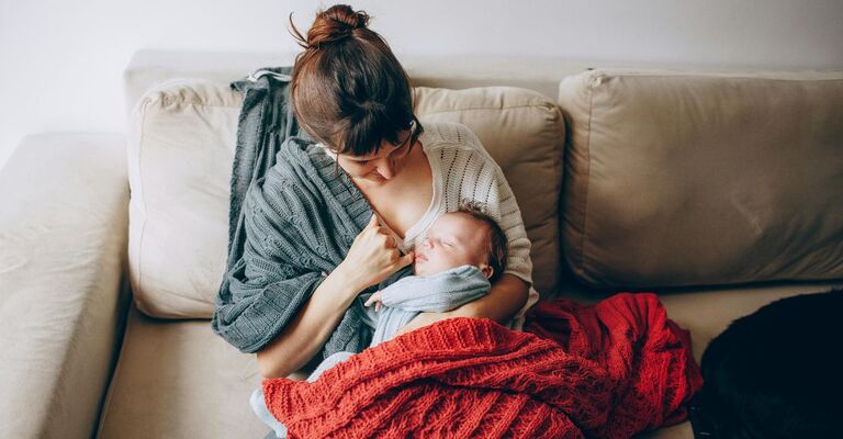 Mamma che sul divano sta allattando