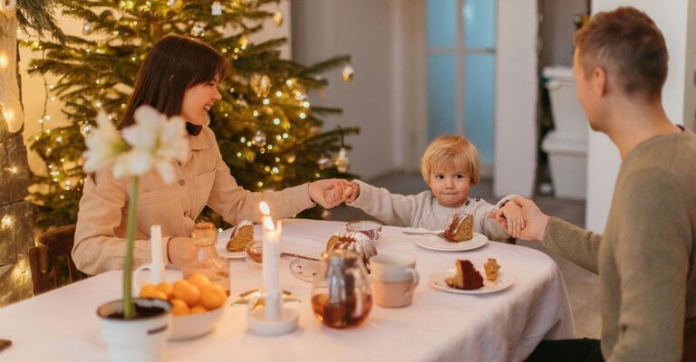 Genitori con bimbo piccoli mentre mangiano i dolci a Natale