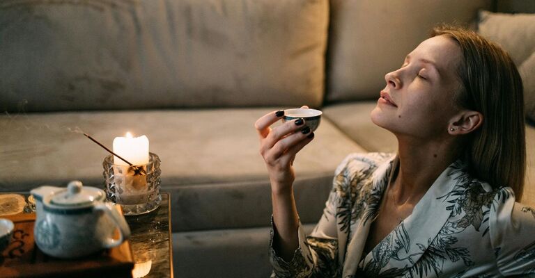 Donna che annusa il profumo di candele e incensi