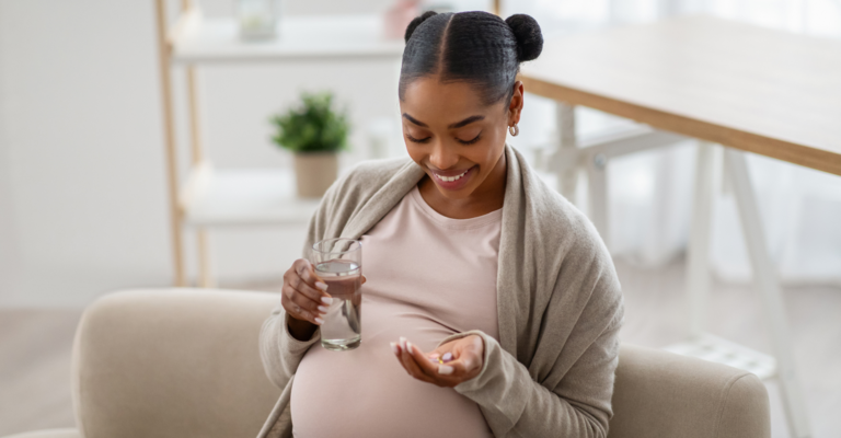 Donna incinta che sta per assumere una compressa