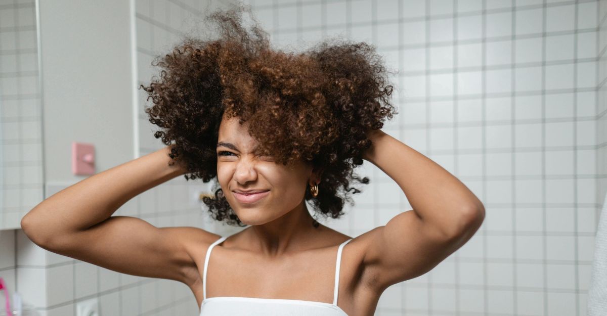 Ragazza che si specchia e guarda i capelli allo specchio