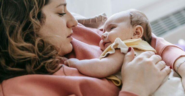 Mamma sdraiata con bimbo sul petto