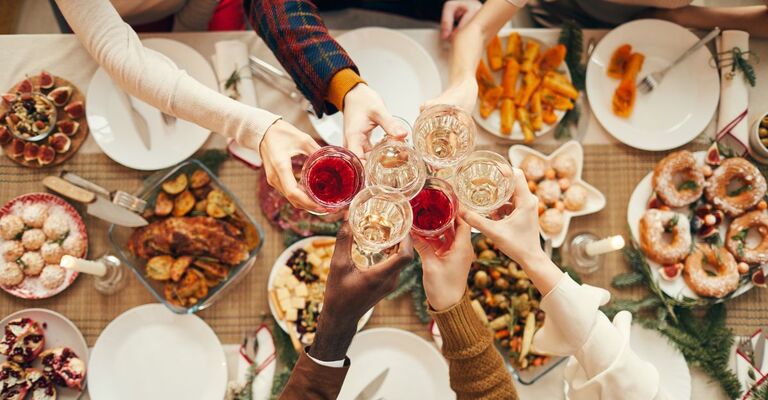 Brindisi natalizio con tavolata di sfondo