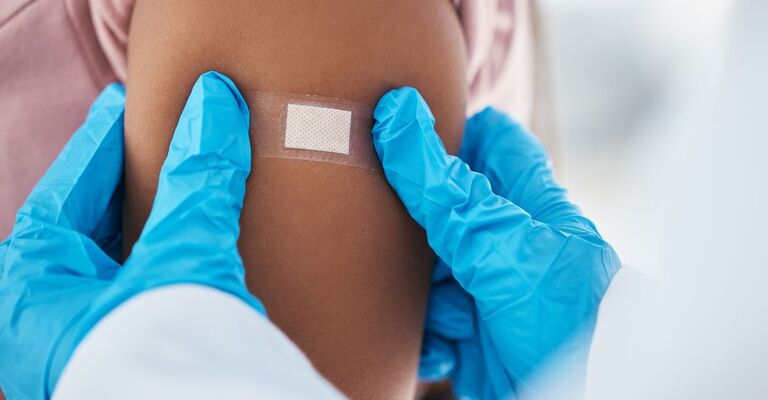 Un medico mette un cerotto ad un paziente