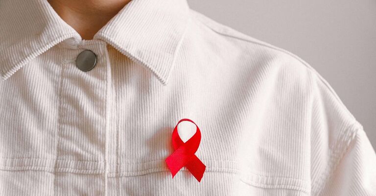 Persona con fiocco rosso per l'AIDS sulla giacca