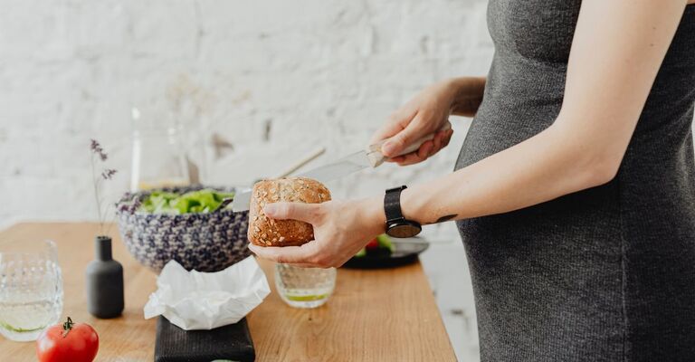 Donna incinta si prepara un panino