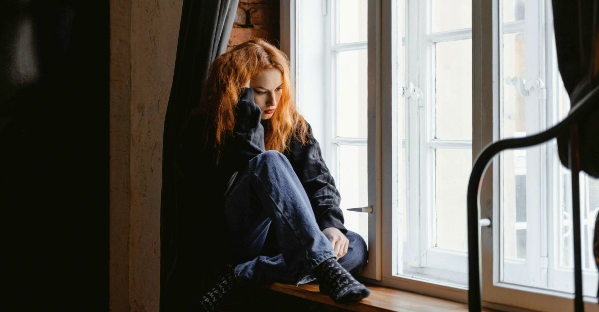 Ragazza in casa vicino alla finestra che riflette