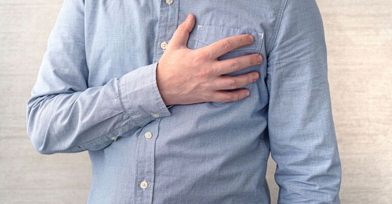 Un uomo che si tiene il petto