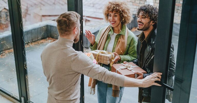 Due amici vanno a casa di un altro per dargli il regalo di Natale