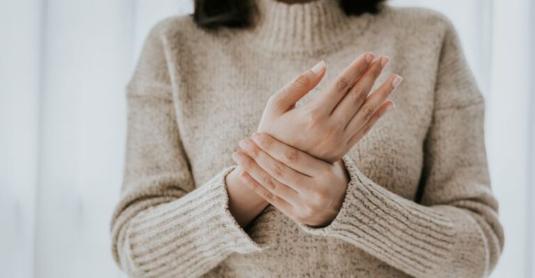 Ragazza che si tocca il polso dolorante