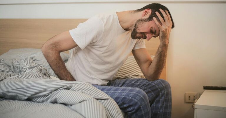 Ragazza seduto sul letto in difficoltà